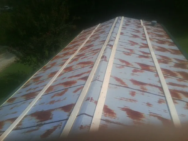 Rusted metal roof panels with new wood purlins before replacement — Storm Damage Roof Repair in Lebeau by Roofing Brothers