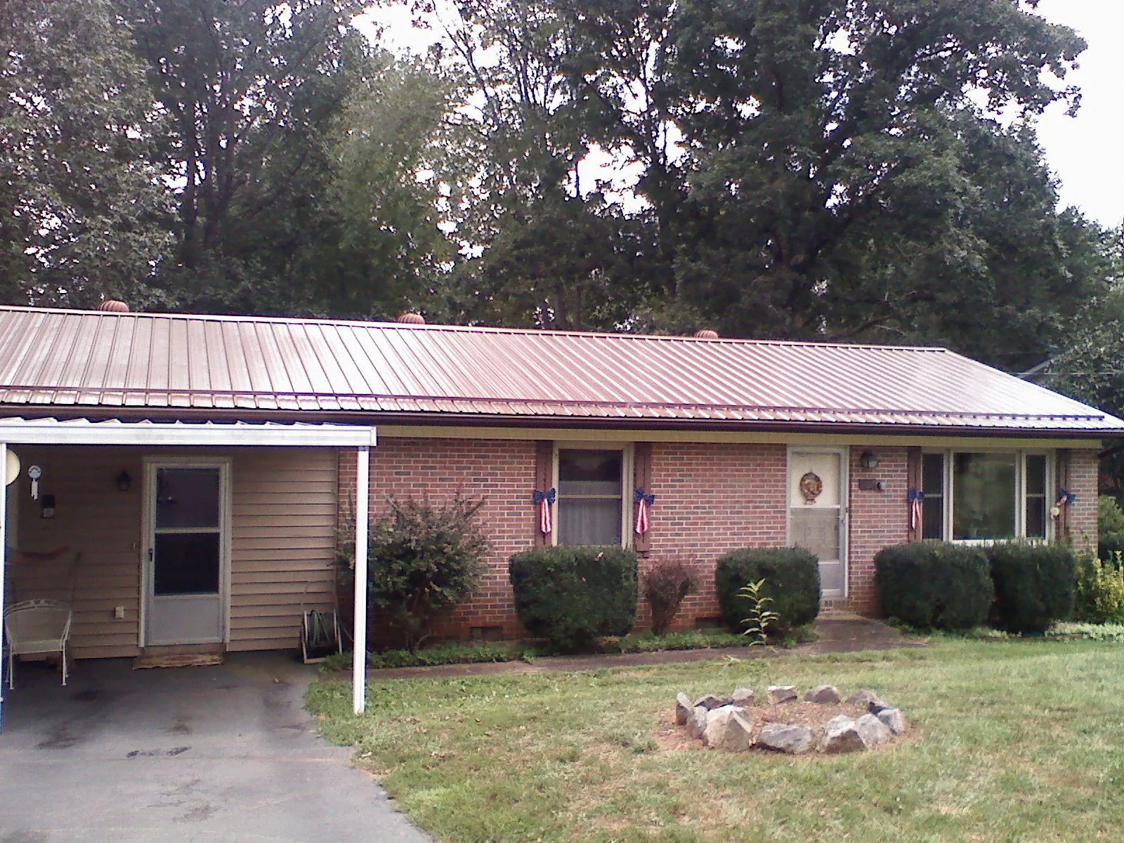 Bronze metal roof and carport on a brick ranch home — Roof Repair work by our crew in Lebeau